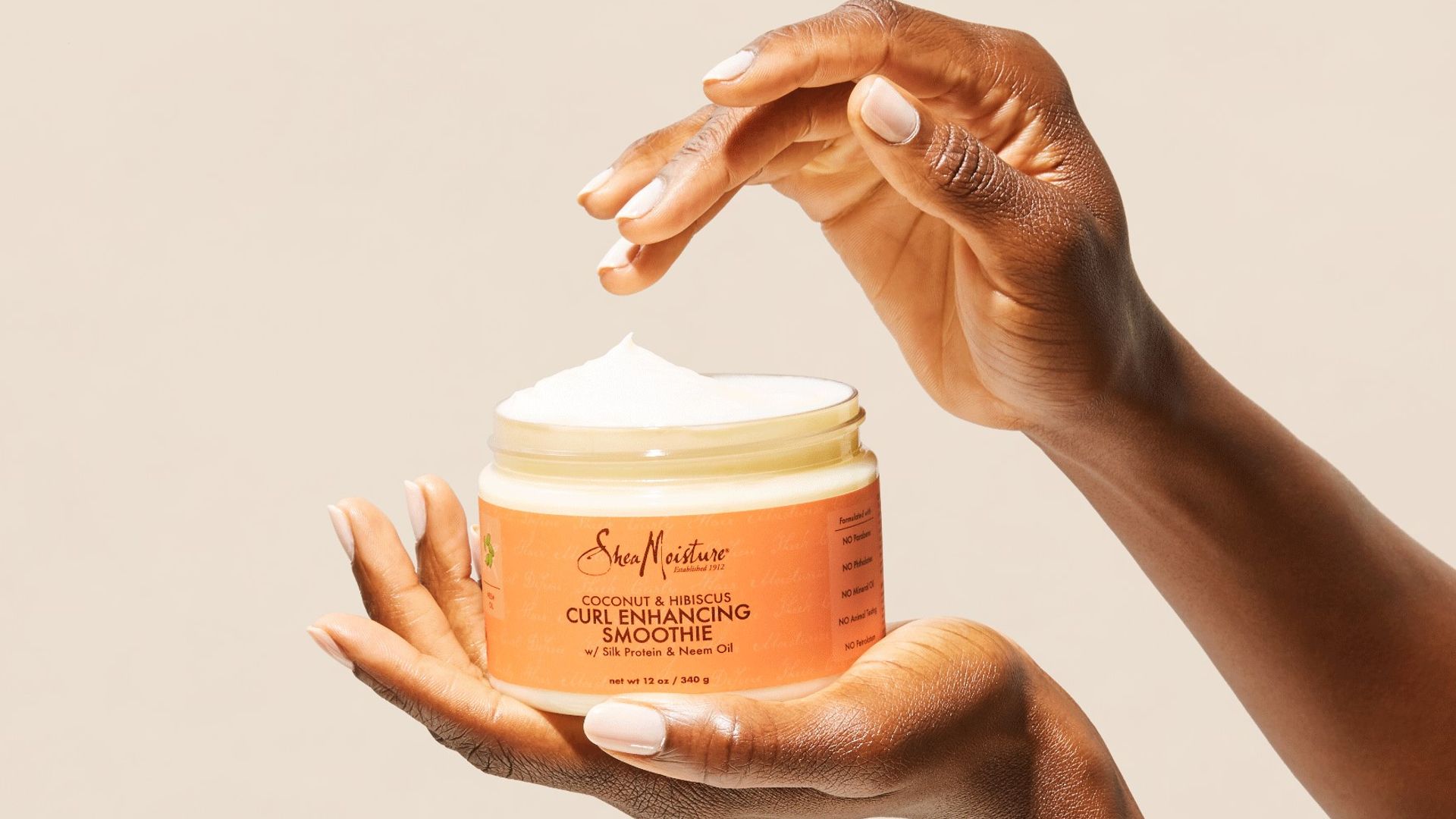 A person holding Sheamoisture's Curl Enhancing Smoothie in their hand