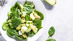 Seasonal Green Salad with Fresh Spinach & Avocado with napkin and fork.