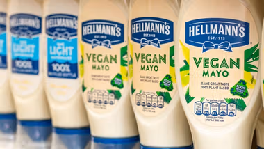 Line-up of Hellmann’s Vegan Mayo and Hellmann’s Light Mayo packs on a supermarket shelf.