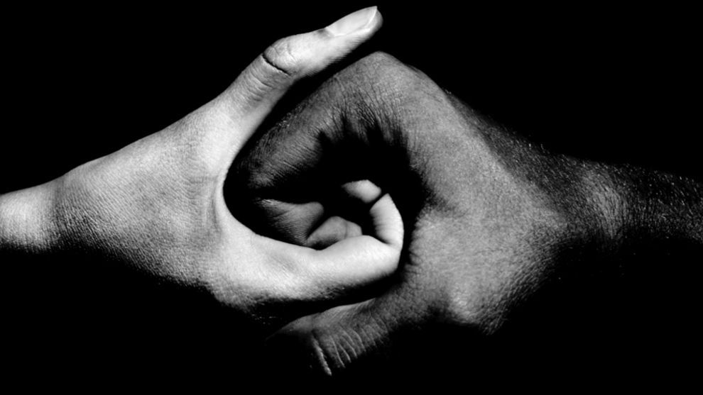 African American and Caucasian people holding hands