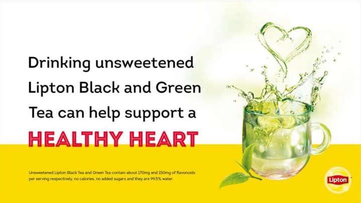 A cup of hot green tea splashing out of cup 