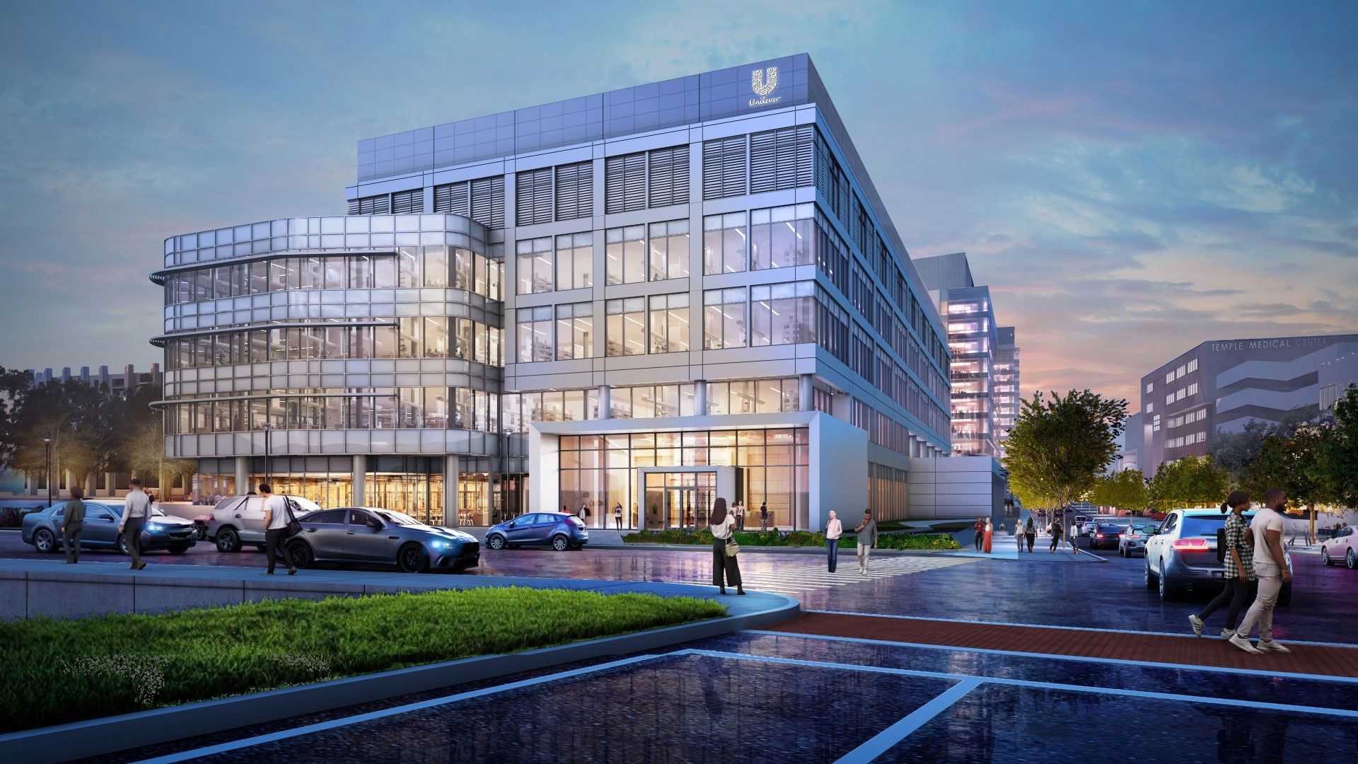 Modern glass-and-steel office building with Unilever logo at dusk, lit interior visible, pedestrians and cars outside on a city street.