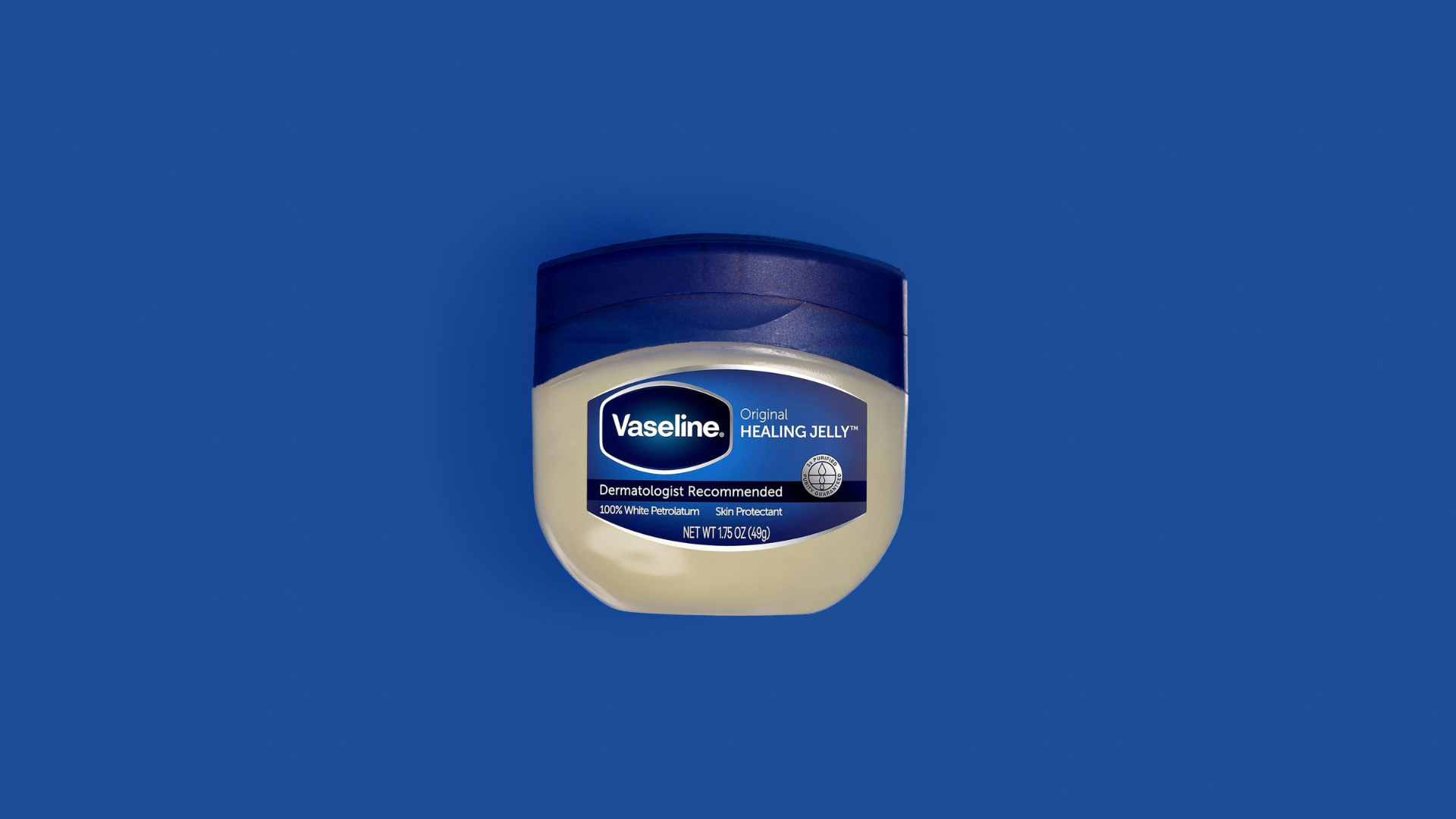 Jar of Vaseline Original Healing Jelly on a blue background.