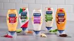 A line-up of Hellmann’s flavoured, squeeze bottle mayos pictured with key ingredients like limes, chillies, garlic and herbs.