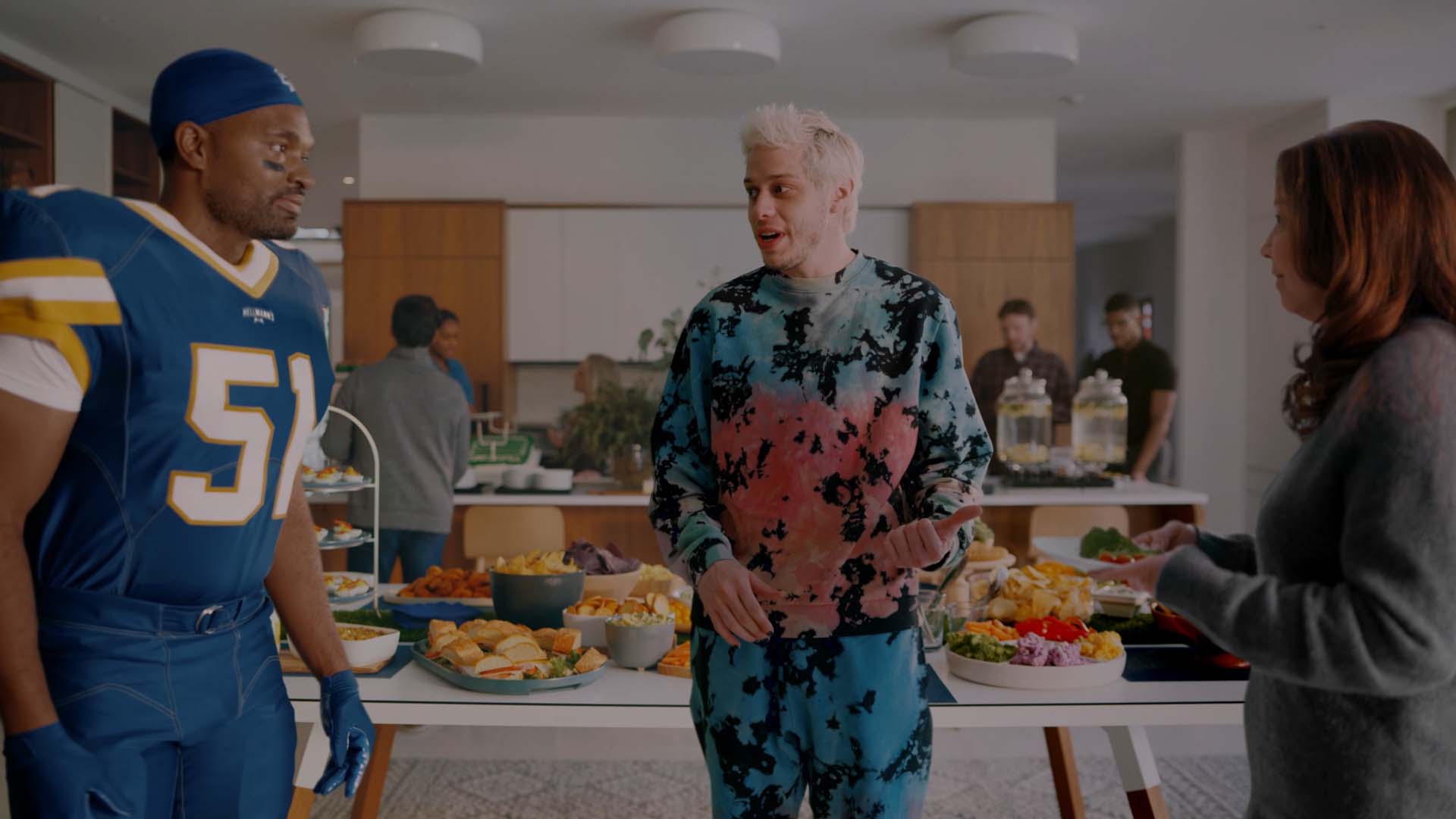 Jerod Mayo in a kitchen with a man and woman